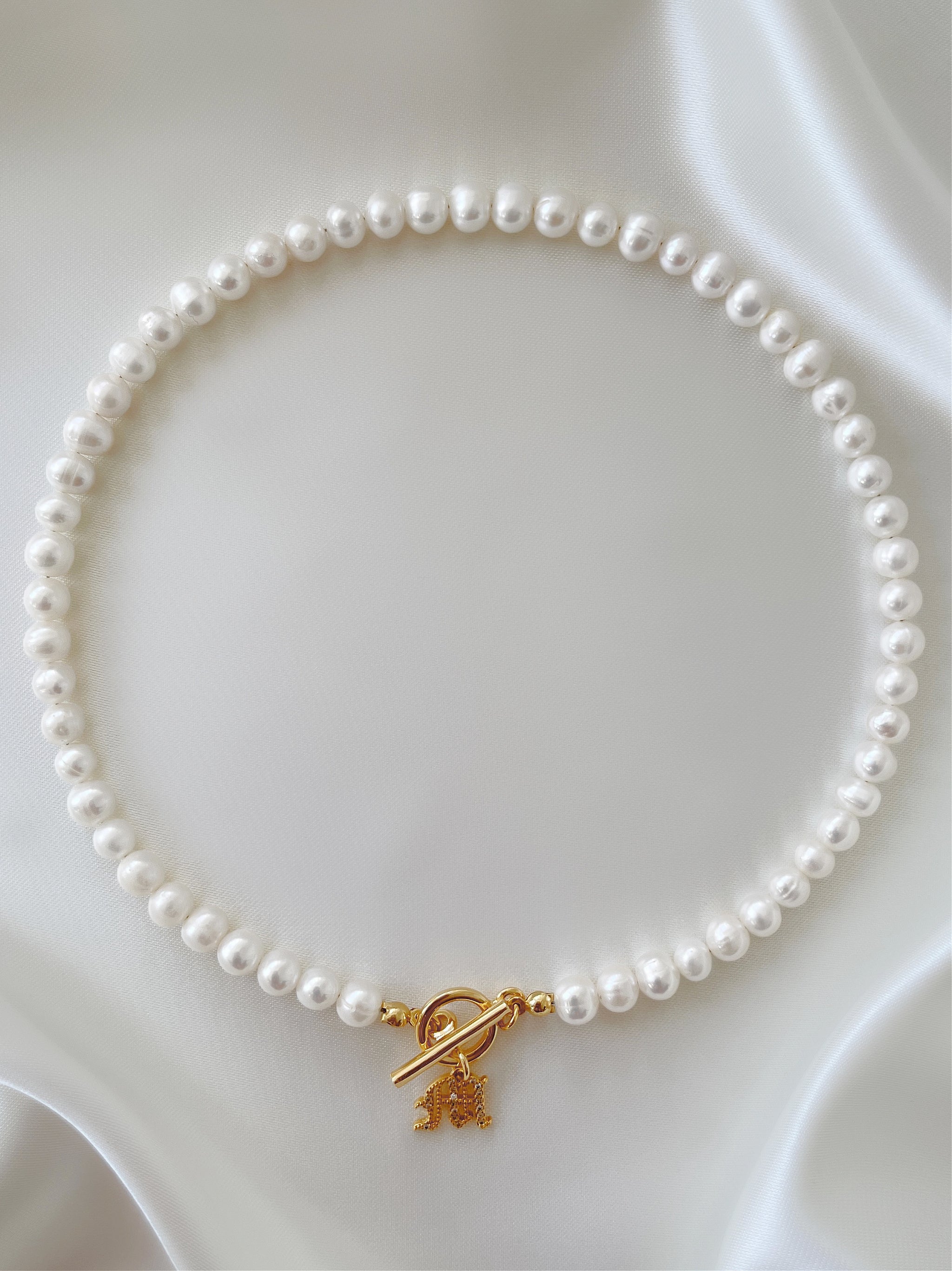 Personalized monogram charm bracelet with white pearls and toggle clasp.